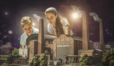 Zwei Kinder betrachten das Model einer Fabrik im Little BIG City Berlin