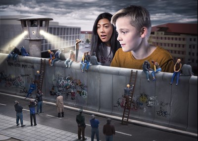 a boy and a girl watch the reconstruction of the Berlin wall with graffiti at Little BIG City Berlin