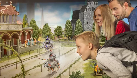 Eine Familie schaut sich ein Ritterturnier in Miniatur im Little BIG City Berlin an 