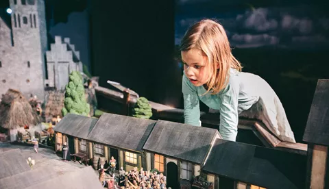 Little girl watches a historical miniature of medieval Berlin at Little BIG City Berlin